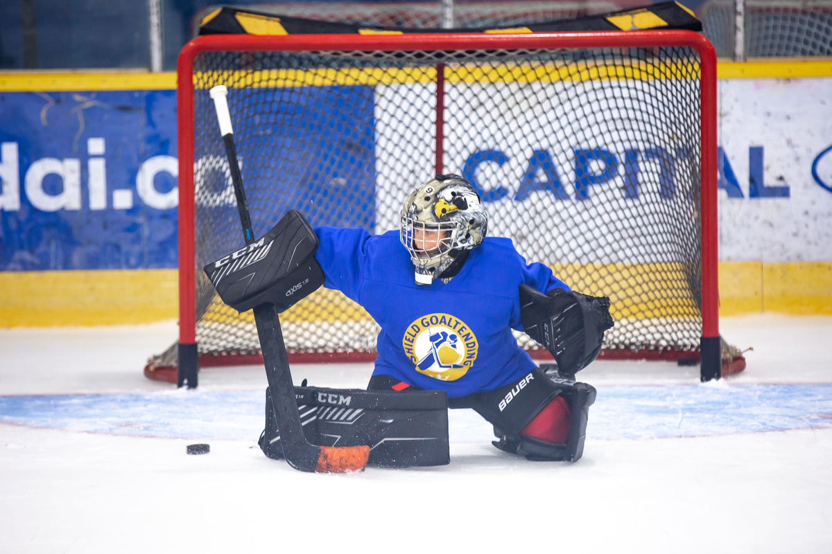 Young goalie making a save at a Shield Goaltending session